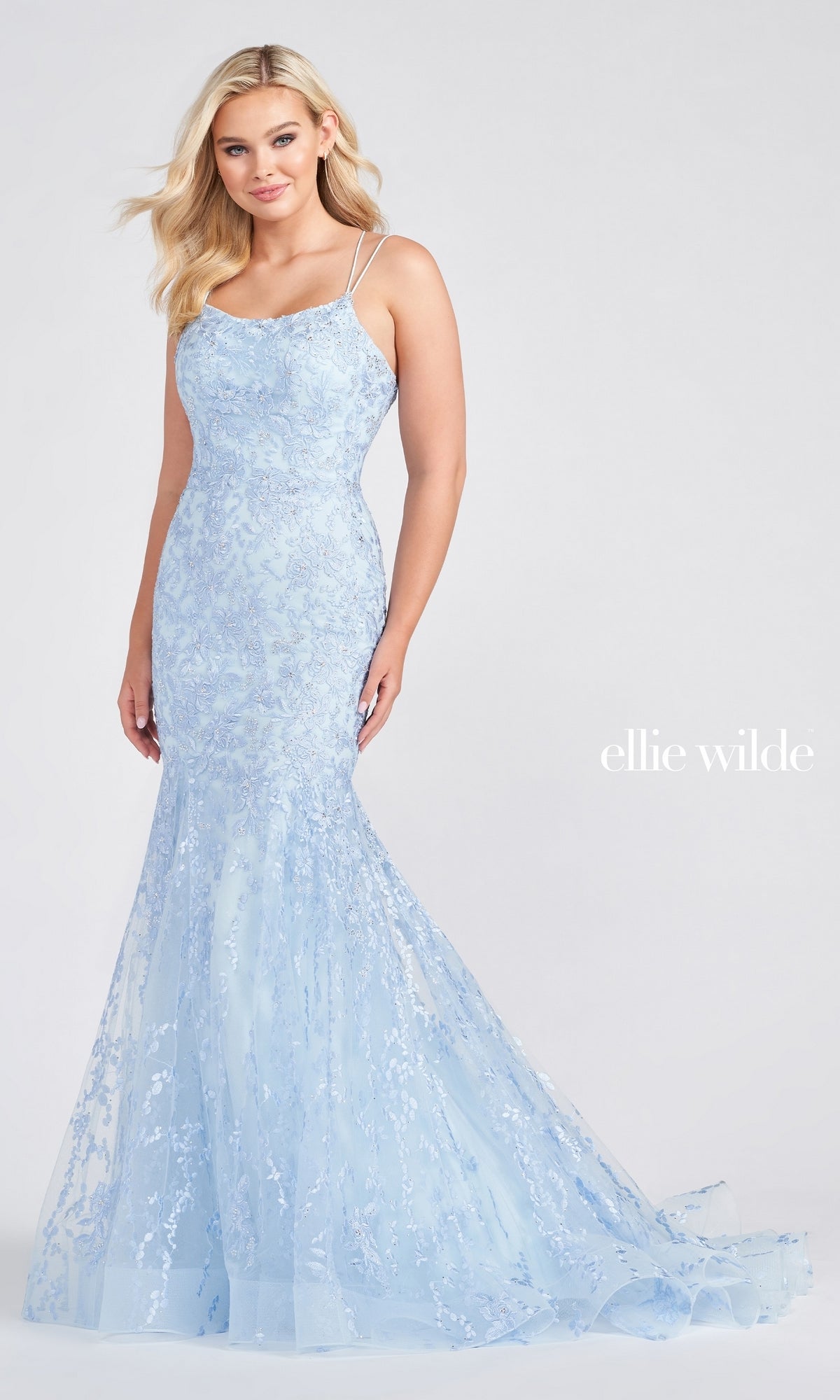 A woman wears a light blue, floor-length Long Lace Mermaid Prom Dress with a fitted silhouette, strappy back, and sequin details by Ellie Wilde. She stands against a plain background. The text